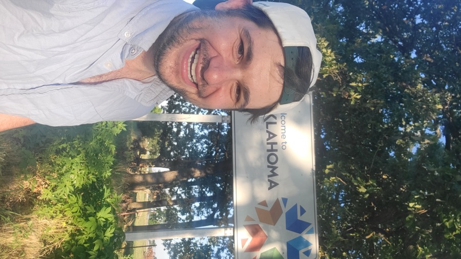 Jack Maguire at the Oklahoma welcome sign on a road trip