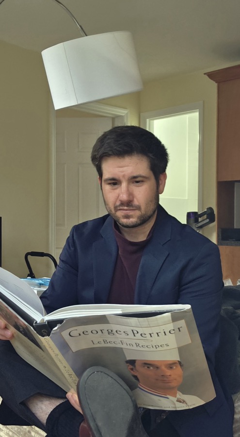 Jack Maguire reading a magazine at home