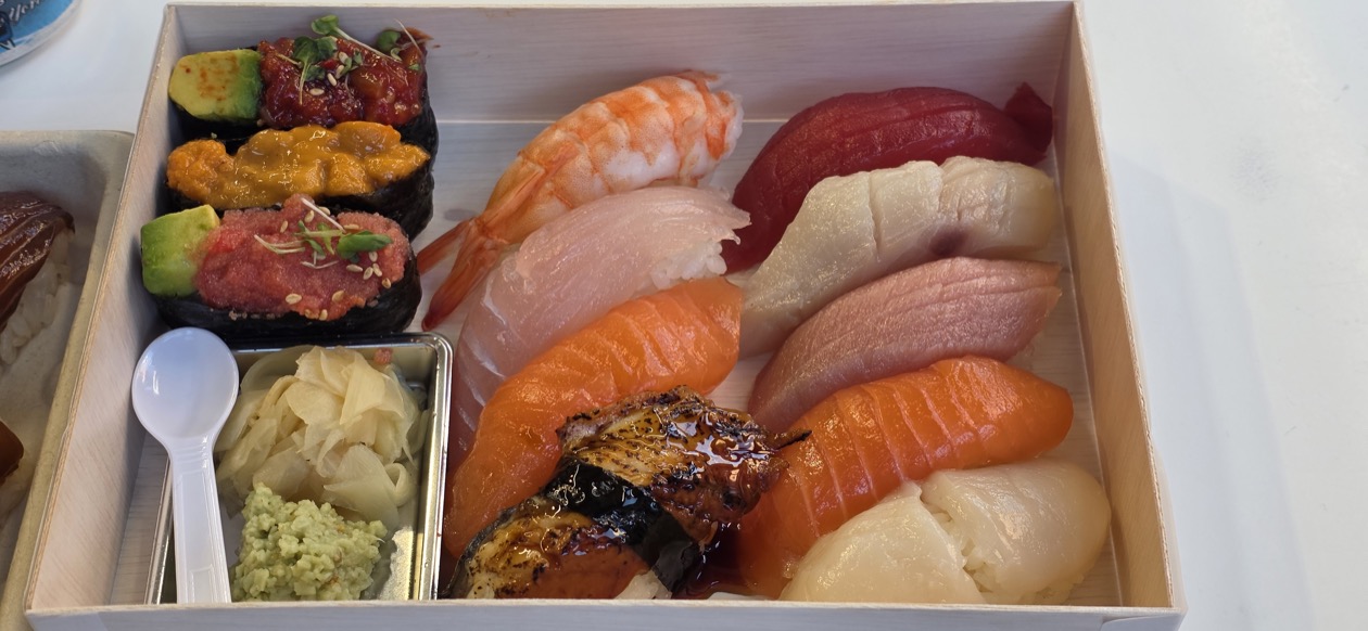 Premium nigiri assortment in a wood box: toro, uni, shrimp, and salmon