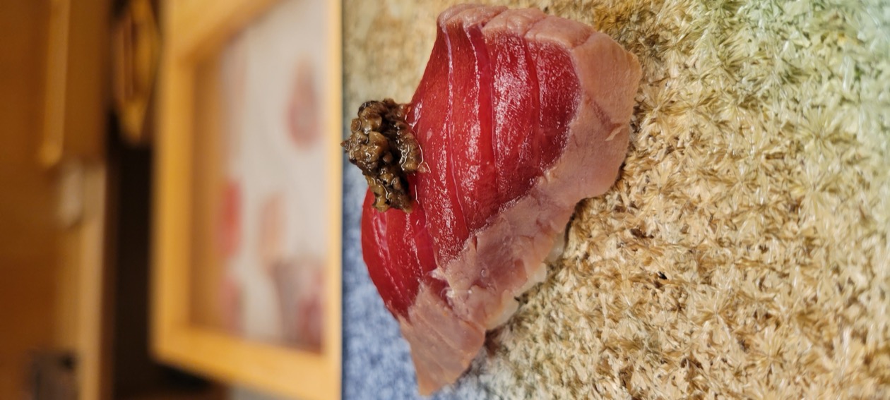 Otoro nigiri with truffle on a woven plate